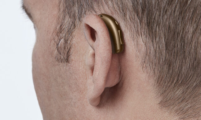 miniRITE_T_H1-2023_C093ChestnutBrown_AngleB45_Close-up_In-On-Ear_MS_6896_Man_1200x800px